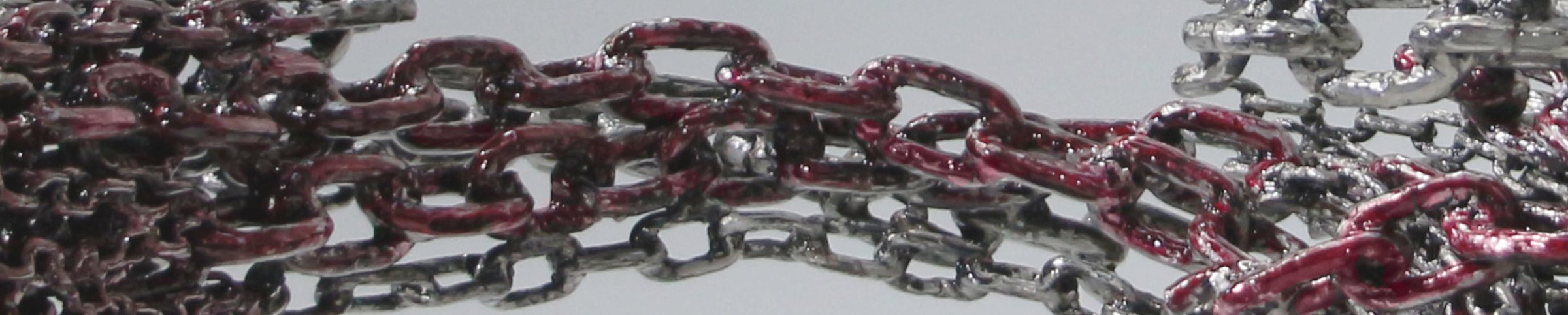 Dettaglio macro delle catene metalliche riciclate, tonalita' rossa
